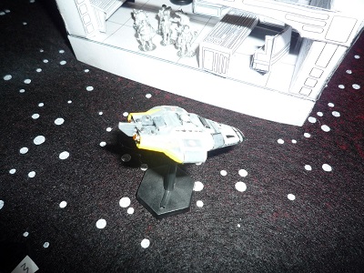 A Beowulf Free Trader starship miniature on a starfield battlemap, next to a Beowulf starship bridge mock-up in 3D